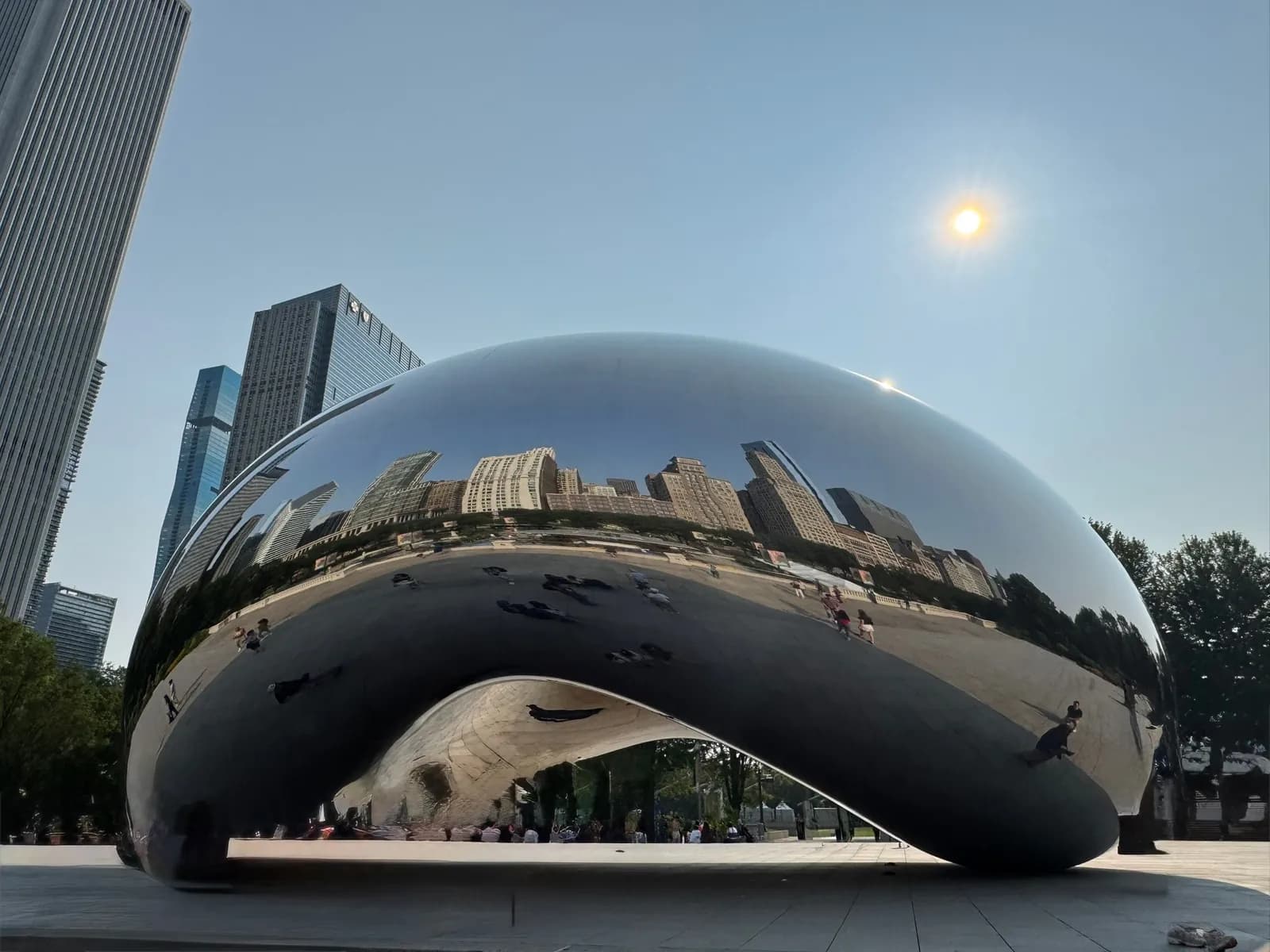The Bean in Chicago, its mirrored surface bending the skyline and the people in front of it.