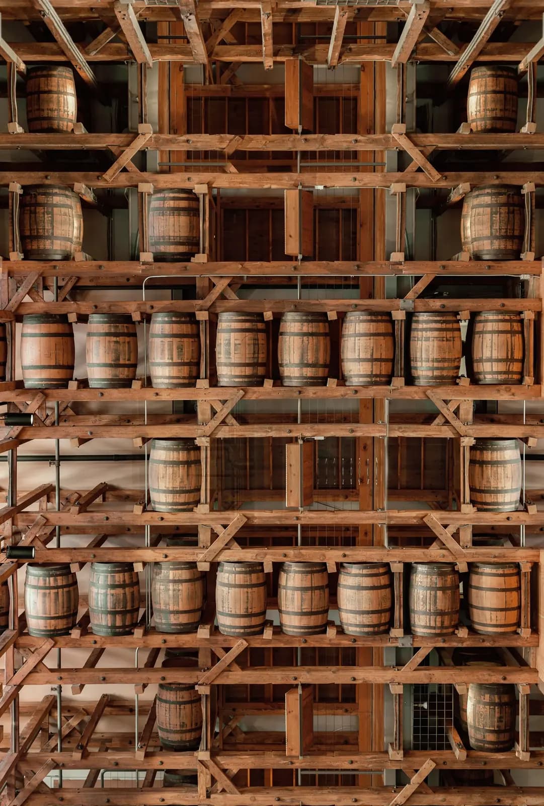 Rows of bourbon barrels stacked in a rickhouse.