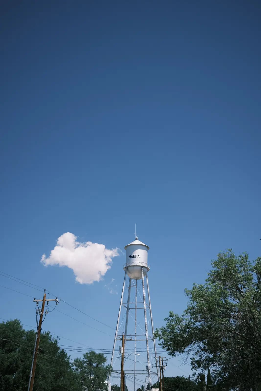 A small-town water tower against a blue sky.